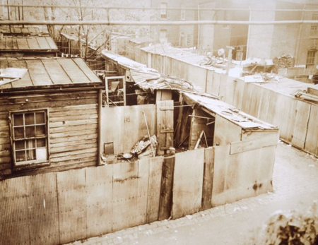 Shacks made of corrugated metal next to a dirt road